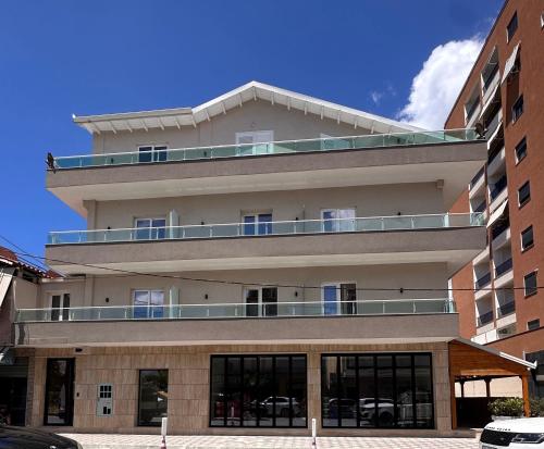 a tall building with a balcony on top of it at Kanaj Rooms and Apartments in Vlorë