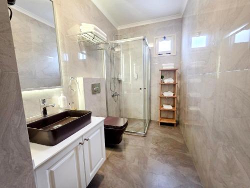 ein Badezimmer mit schwarzem Waschbecken und Dusche in der Unterkunft Kamer Exclusive Hotel & Suites in Cesme