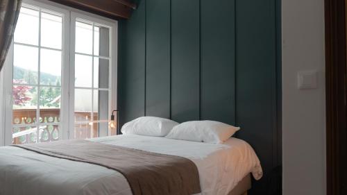 a bed with two pillows in a room with a window at Auberge Du Roselet in Duingt