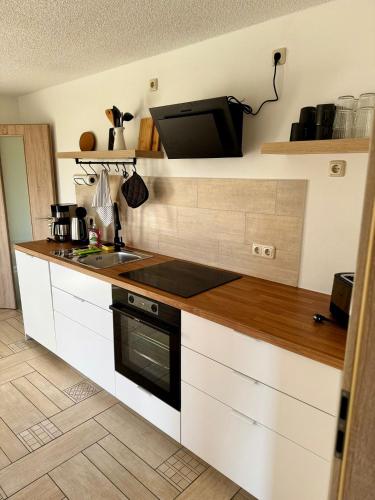a kitchen with a counter with a sink and a microwave at FeWo Am Feldrand in Prebberede