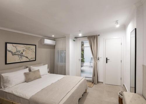 a bedroom with a large white bed and a door at Garden House Retreat-Suite in Drama
