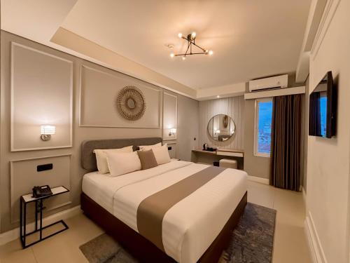 a bedroom with a large bed and a television at Hotel FortunaGrande Malioboro Yogyakarta in Yogyakarta