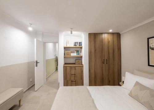 a bedroom with a white bed and a wooden door at Garden House Retreat-Suite in Drama