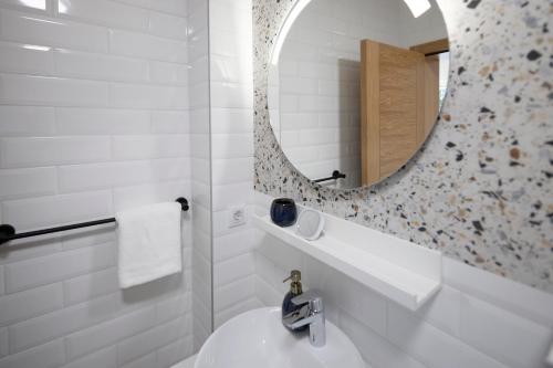 a white bathroom with a sink and a mirror at Artemis Escape Suites Srebrno Jezero in Veliko Gradište