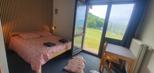 a bedroom with a bed and a large window at Le Shantoné in Saint-Michel-de-Maurienne