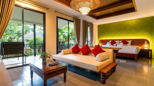 a hotel room with a bed and a room with two beds at Anda Lanta Resort in Ko Lanta