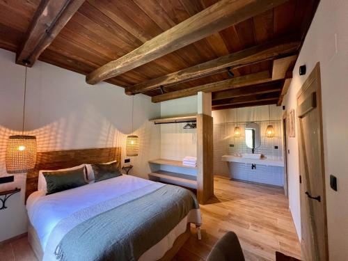 a bedroom with a large bed and a bathroom at Casa Corbeiras Apartamento 1 in A Pontenova