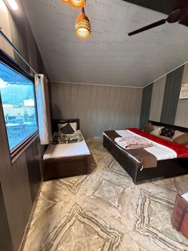 a bedroom with two beds and a window at Valley King Resort in Mohan Chatti