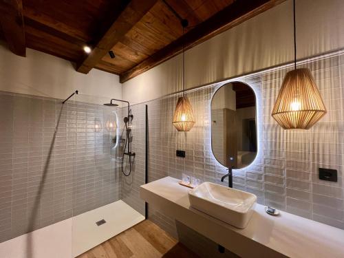 a bathroom with a sink and a shower and a mirror at Casa Corbeiras Apartamento 1 in A Pontenova