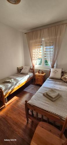 two beds in a room with a window at Casa Vacanza GERONIMI in San Cassiano