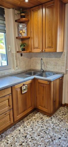 a kitchen with wooden cabinets and a sink at Casa Vacanza GERONIMI in San Cassiano