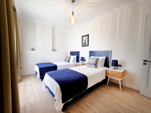 ein Schlafzimmer mit zwei Betten und einem Tisch mit Nachttisch in der Unterkunft Kamer Exclusive Hotel & Suites in Cesme