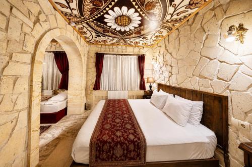 a bedroom with a bed in a stone wall at Corner İn Cappadocia in Ortahisar