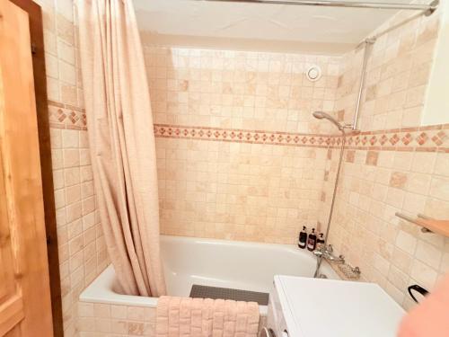 a bathroom with a white tub and a sink at LOVErbier with pool in building, steps to Place Central in Verbier
