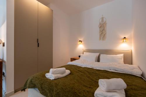 a bedroom with a large bed with towels on it at Asini deluxe suite 2, with rooftop terrace and breathtaking views in Asíni