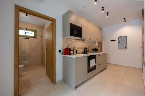 a kitchen with a sink and a stove at Asini deluxe suite 2, with rooftop terrace and breathtaking views in Asíni