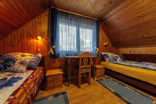 a bedroom with two beds and a desk and a window at János Nyaraló in Balatonmáriafürdő