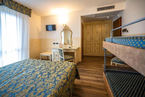 a hotel room with a bunk bed and a mirror at Hotel Confine in Colà di Lazise