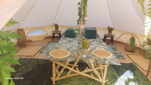 a tent with a table and chairs in a room at dame nature in Le Pener