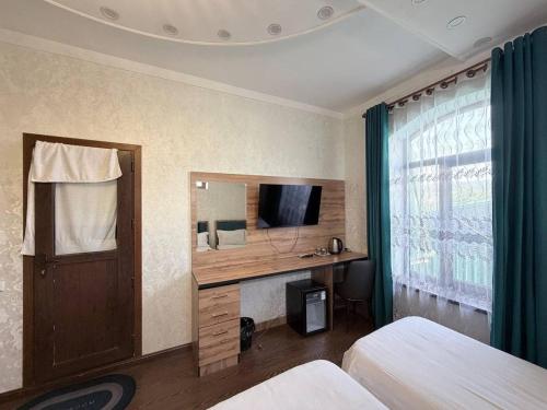 a hotel room with a desk and a television at Soro Hotel in Dushanbe