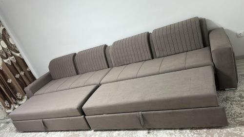 a brown couch sitting in a living room at 7 Su Nury in Almaty
