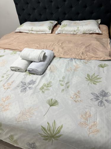 a bed with a blanket and two pillows on it at 7 Su Nury in Almaty