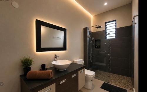 a bathroom with a sink and a toilet and a shower at Beach luxury Penthouse in Flic-en-Flac