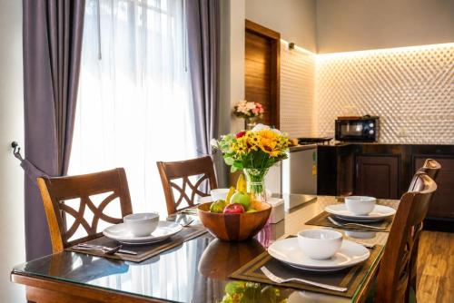 a dining room table with a bowl of fruit on it at Arterra Haven , Aonang Krabi in Ao Nang Beach