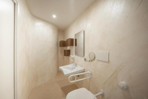 a bathroom with a sink and a toilet at Deledda Rooms Boutique in Budoni