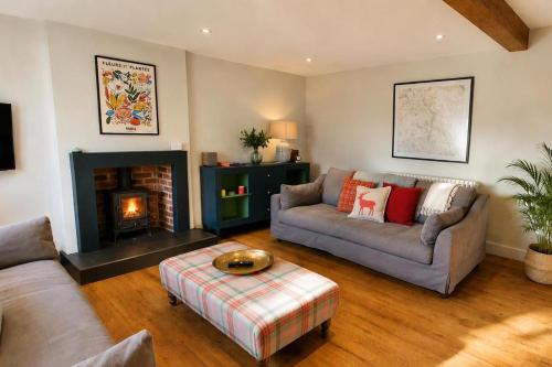 a living room with two couches and a fireplace at Bakers Yard Cottage, Bonsall, Peak District in Bonsall