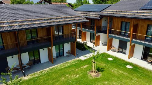 Luftaufnahme eines Hauses mit Solarpaneelen auf dem Dach in der Unterkunft Das Exter - modernes Self Check-in Hotel am Chiemsee in Übersee