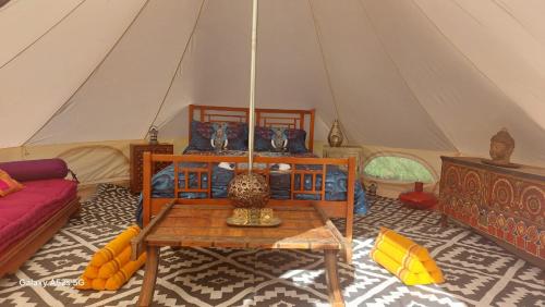 a room with a bed and a table in a tent at tente india in Le Pener