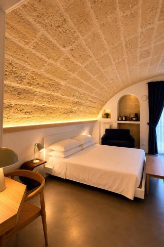 a bedroom with a large bed with a ceiling at Il Giramondo Suite&Room in Matera