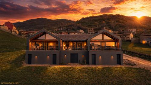 a house on a hill with the sunset in the background at La Finca del Valle in Valle de Vegacervera