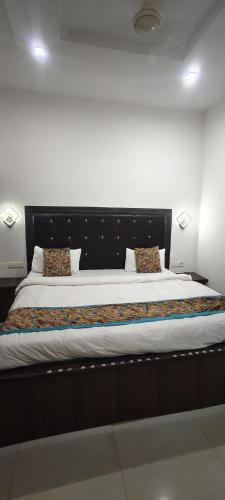 a bedroom with a large bed with a black headboard at Hotel Ansh Palace - Village Near Taj Mahal Agra in Tājganj