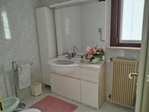 a white bathroom with a sink and a toilet at Alle Nuove Stelle in Udine