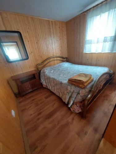a bedroom with a bed in a room with a window at Будиночок Перший rio de pulmo in Pulʼmo