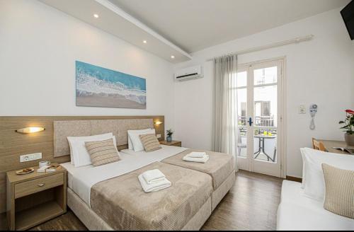 a hotel room with two beds and a window at Mare Naxia Hotel in Naxos Chora