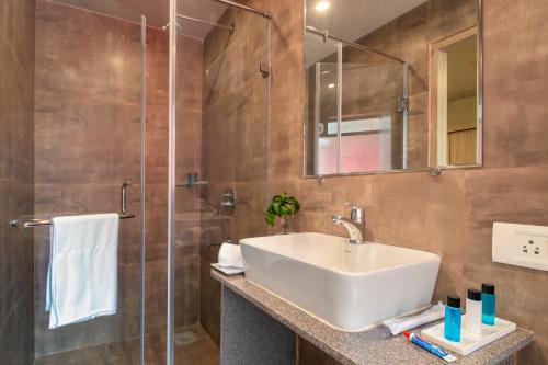 ein Badezimmer mit Waschbecken und Dusche in der Unterkunft Anthurium Hotel in Mapusa