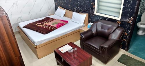 a small bed and a chair in a room at Hotel Siddhant in Pithorāgarh