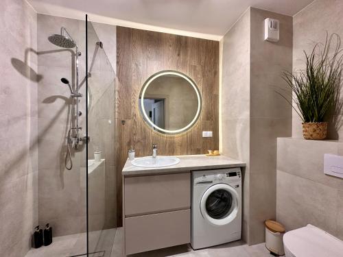 a bathroom with a washing machine and a sink at Apartment Chrzanòw in Chrzanów