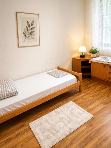 a bedroom with two beds and a table and a rug at Aura Apartment Sarajevo in Sarajevo