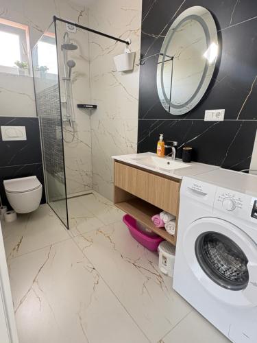a bathroom with a sink and a washing machine at Apartmani Catakovic in Vir