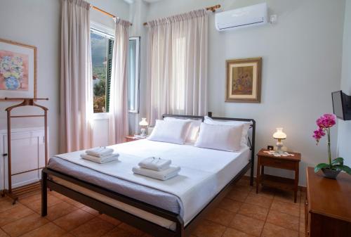a bedroom with a bed with towels on it at Palairos Historic Villa in Paleros