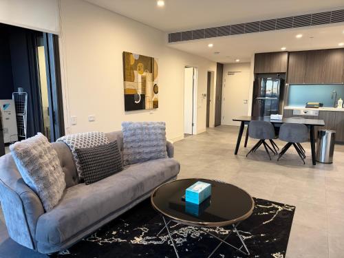 a living room with a couch and a table at Luxurious City View with Gym Pool Parking Playground in Sydney