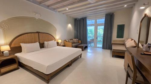 a bedroom with a large bed and a living room at Nilaveli Beach Hotel in Nilaveli