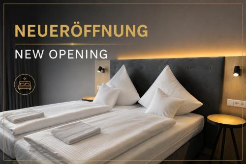 a bed with white sheets and pillows on it at HI Grand City Hotel in Hannover