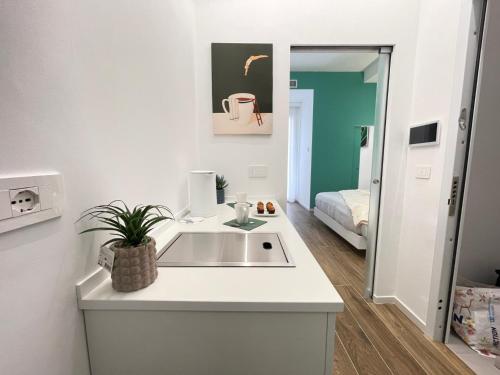 a white kitchen with a sink and a mirror at Alloggio degli Eroi by LocazioniOK in Mola di Bari