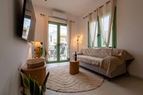 a living room with a couch and a table at Asini deluxe suite 3, with rooftop terrace and breathtaking views in Asíni