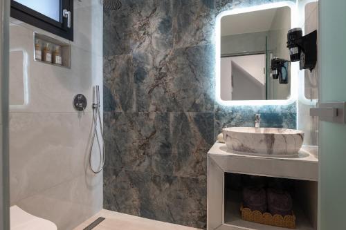 a bathroom with a sink and a shower with a mirror at Mini Boutique Dragani in Sykia Chalkidikis